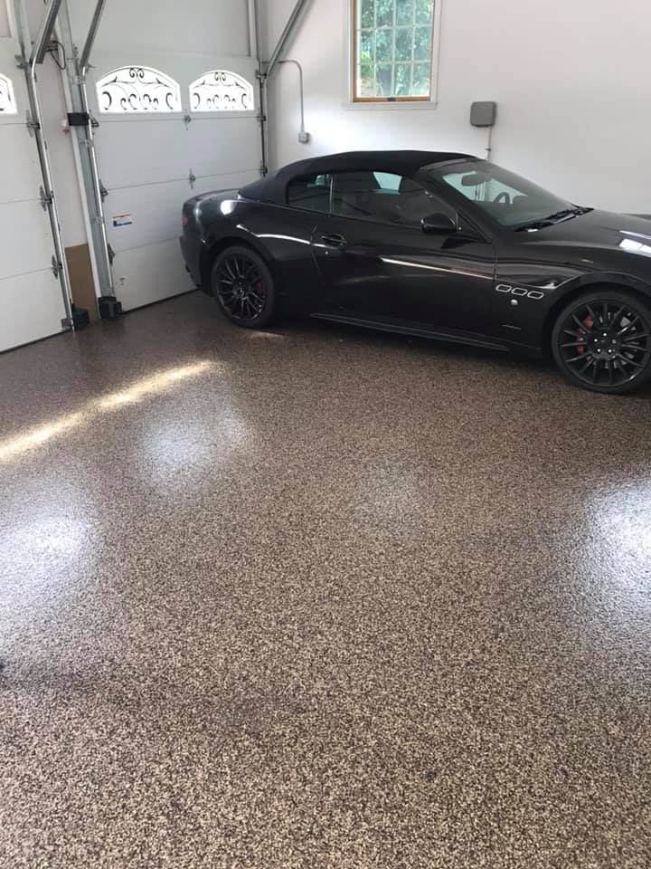 Tan and black flake broadcast garage floor with sports car