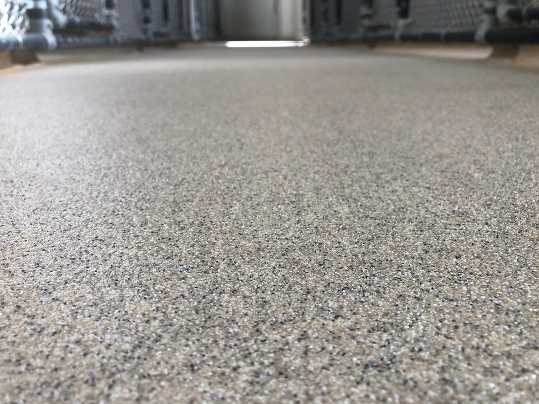 Tan quartz broadcast floor with fine granular texture
